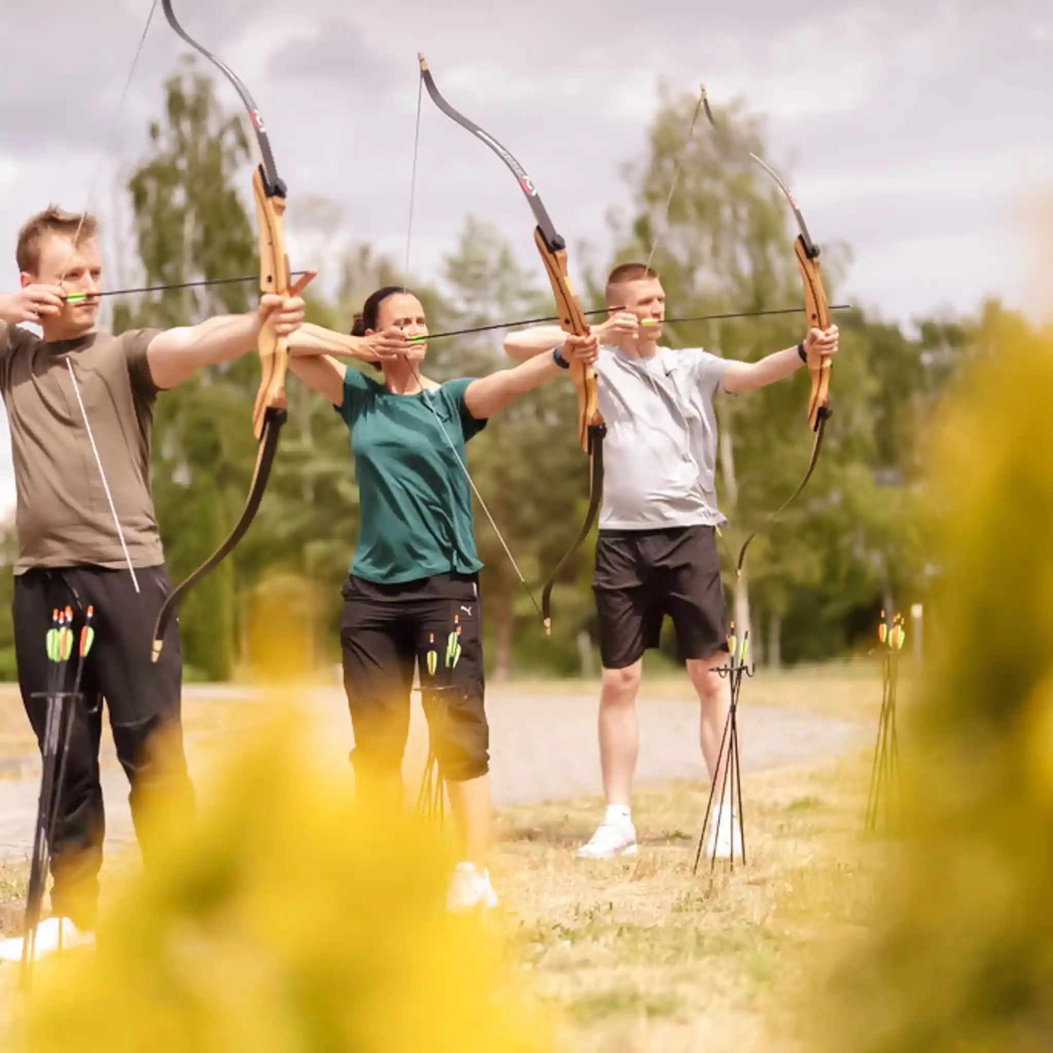 Drei Patienten beim therapeutischen Bogenschießen