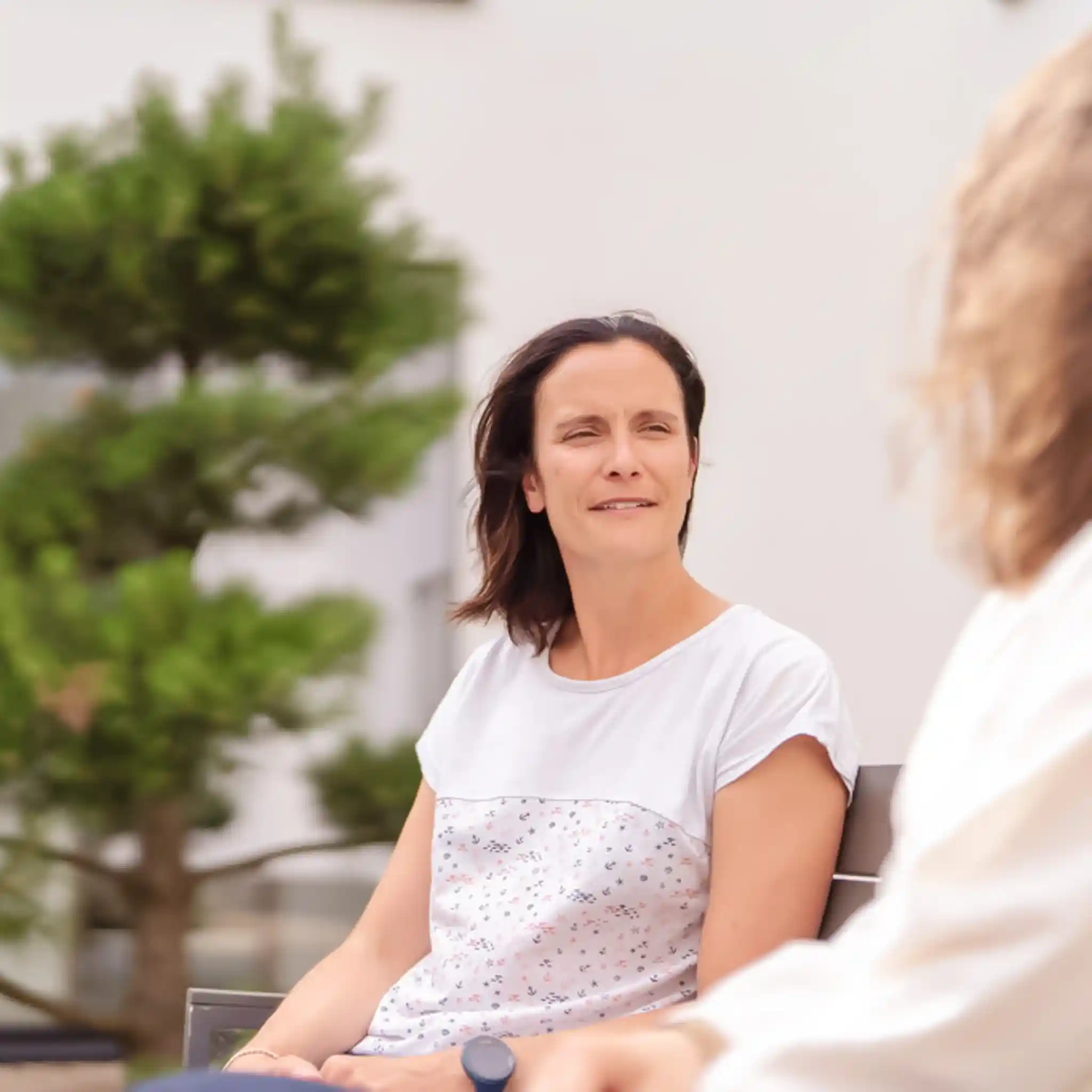 Eine Patientin blickt ihre Therapeutin an und hört gespannt zu.
