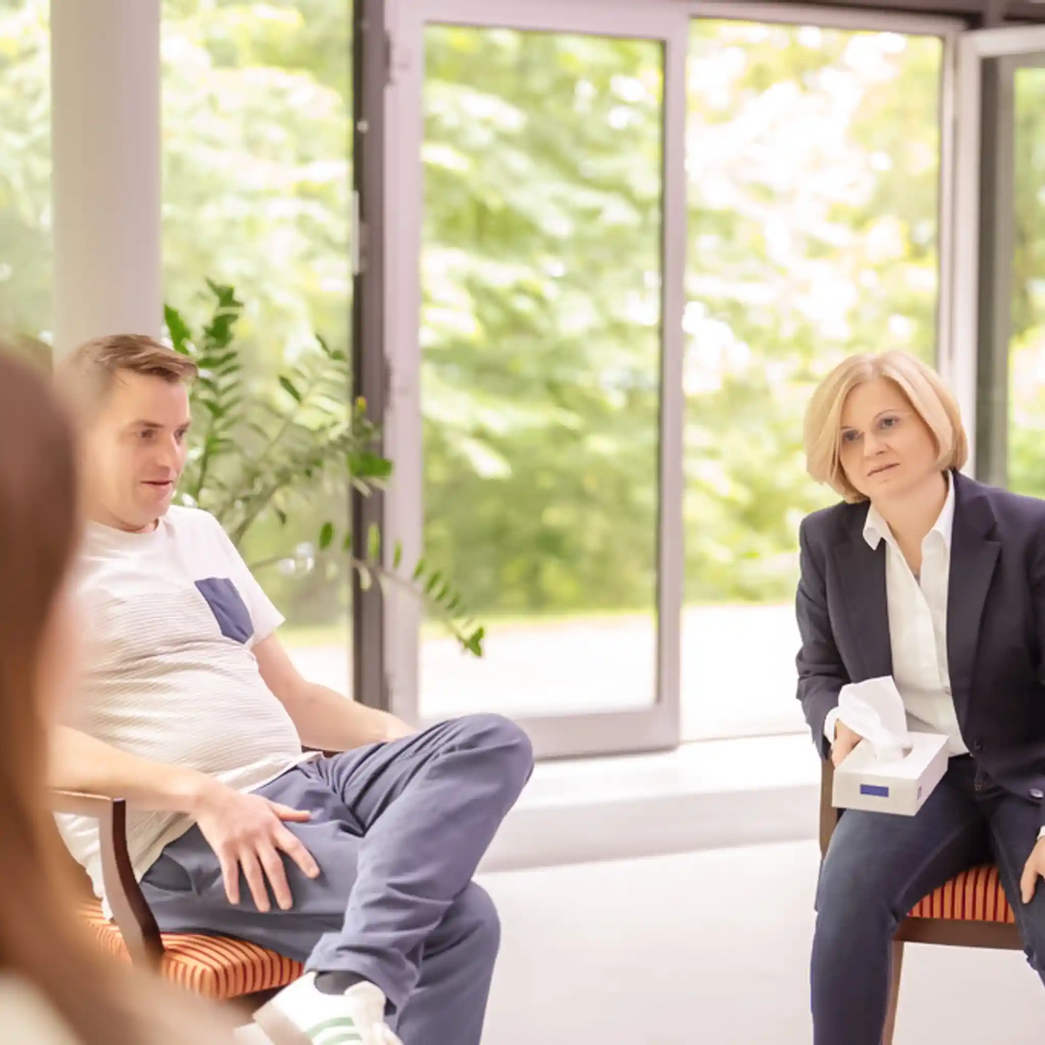 Eine Ärztin beim Durchführen einer Gruppentherapie mit mehreren Patienten.