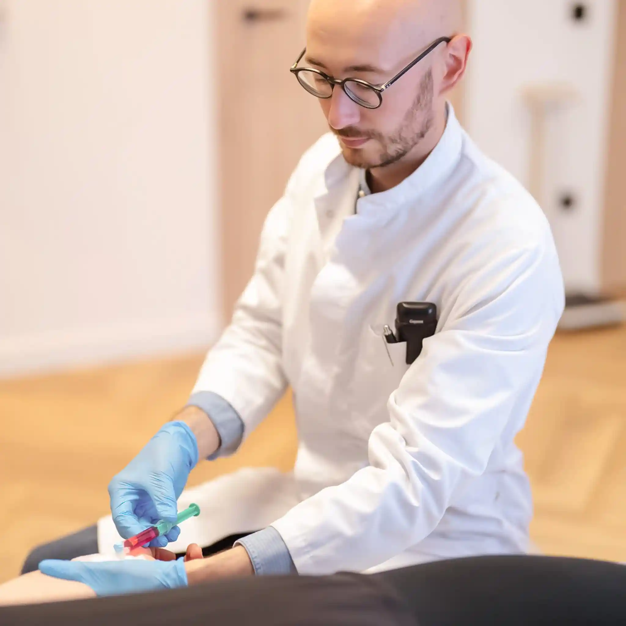 Ein Arzt bei der Blutabnahme eines Patienten