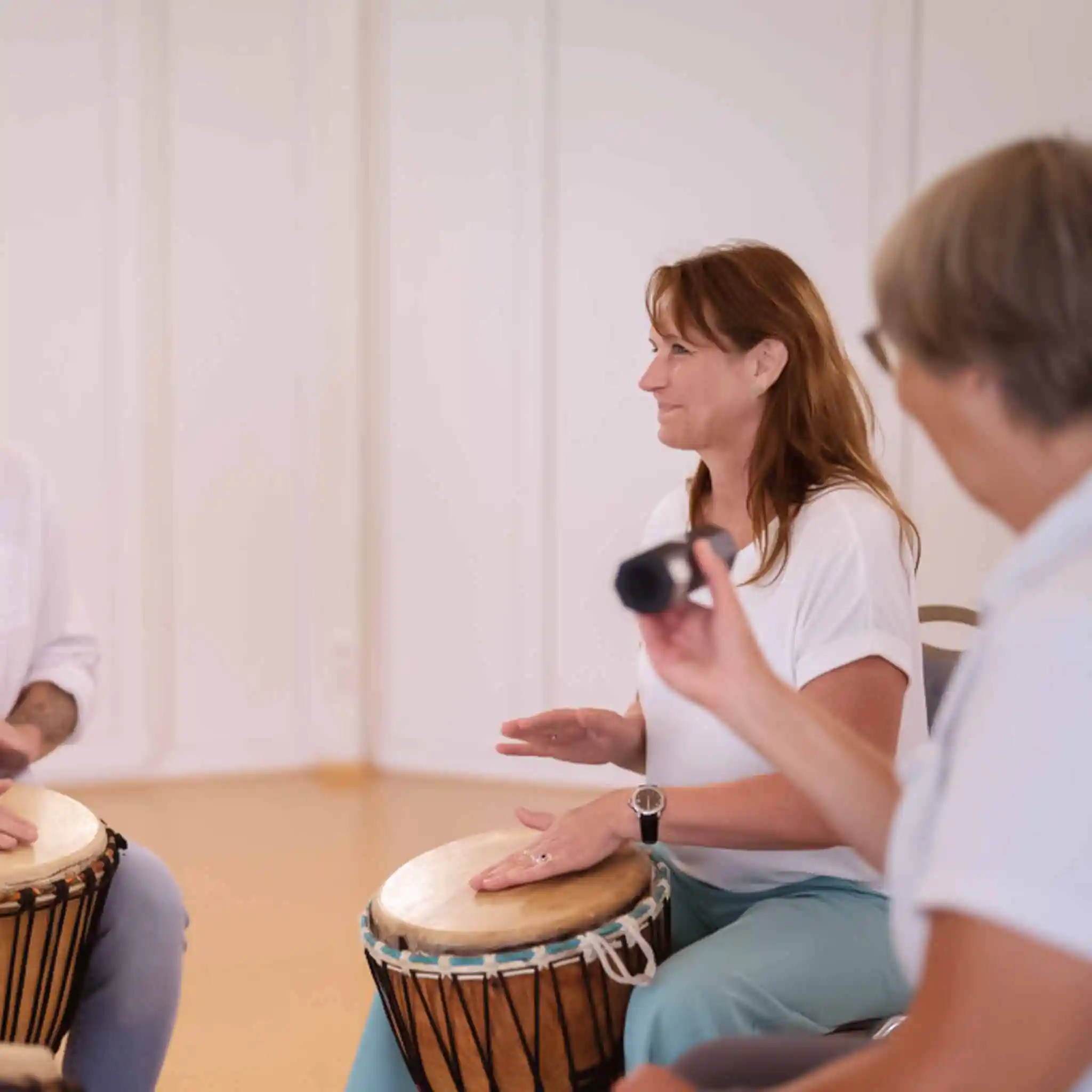 Zwei Patienten trommeln bei der Musiktherapie.