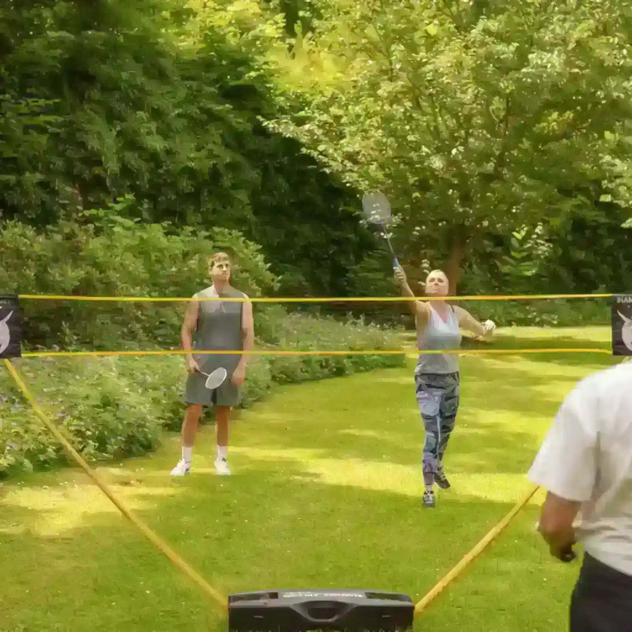 Mehrer Patienten spielen draußen gemeinsam Federball.