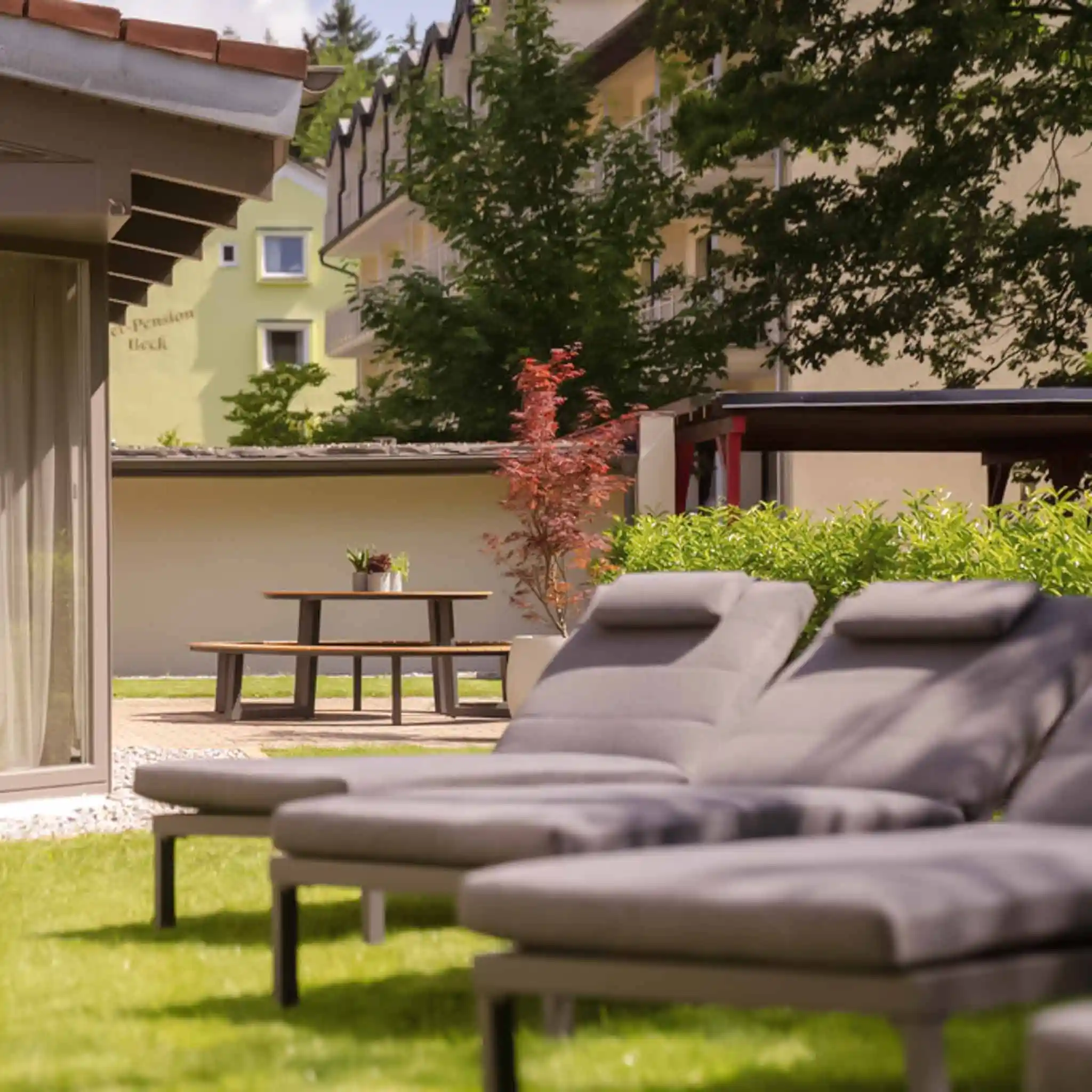 Drei Liegen, die im Außenbereich auf der Wiese stehen.