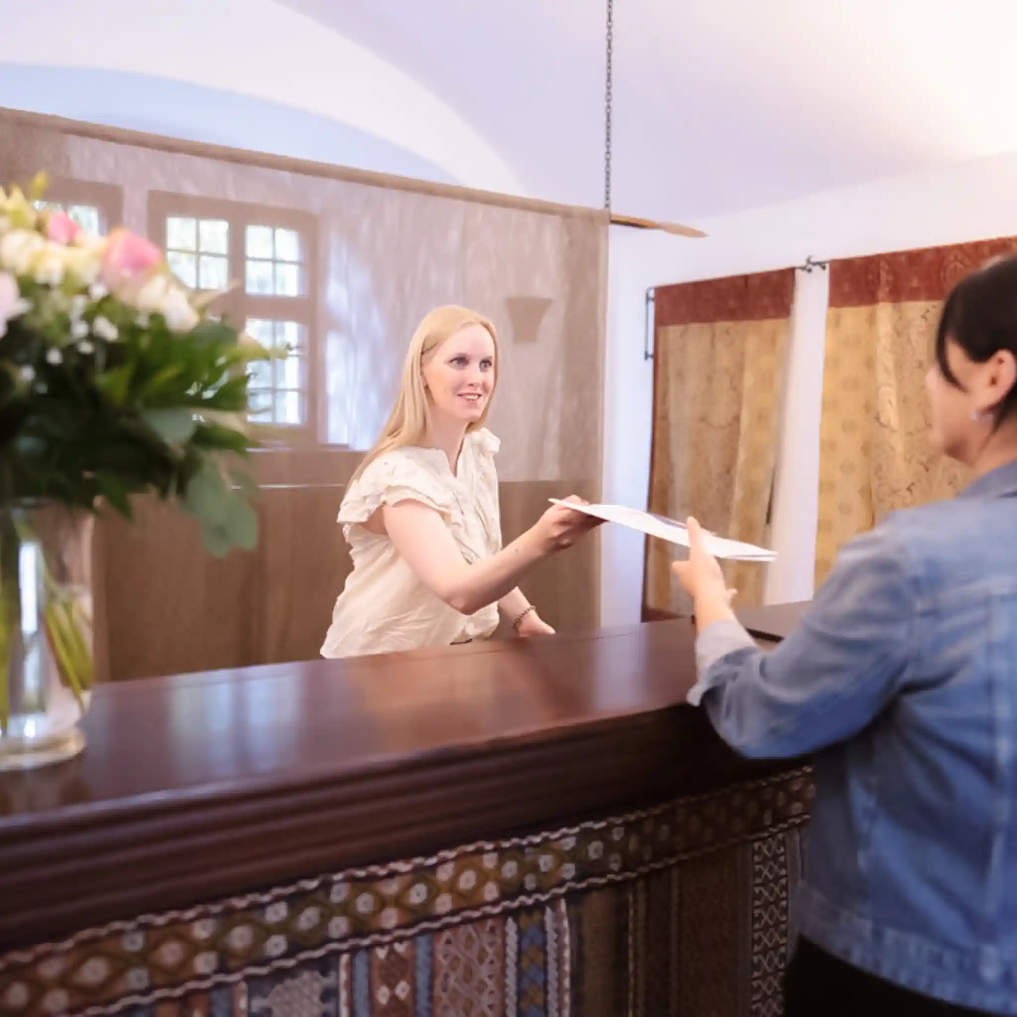 Eine Patientenmanagerin überreicht einer Patientin Informationsmaterialien.