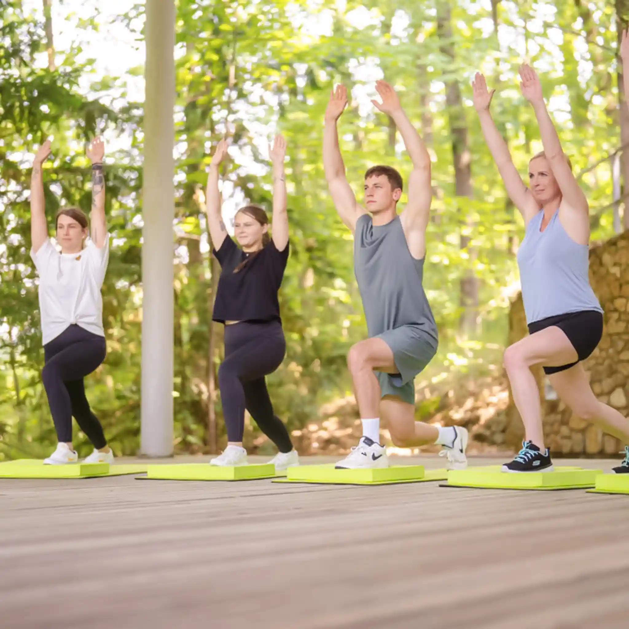 Mehrere Patienten machen Sportübungen und heben die Arme in die Luft.