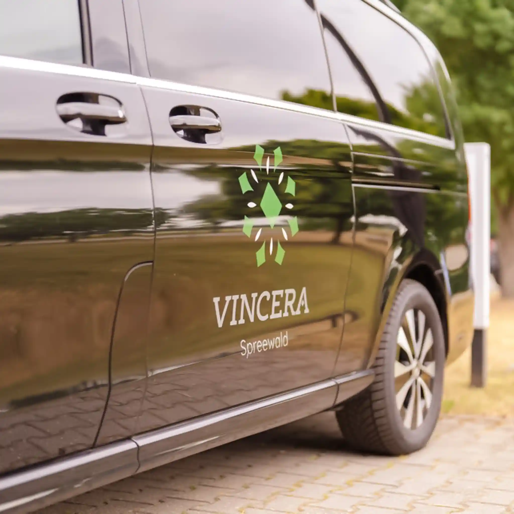 Ein schwarzer Bus mit dem aufgedruckten Logo der Vincera Klinik Spreewald