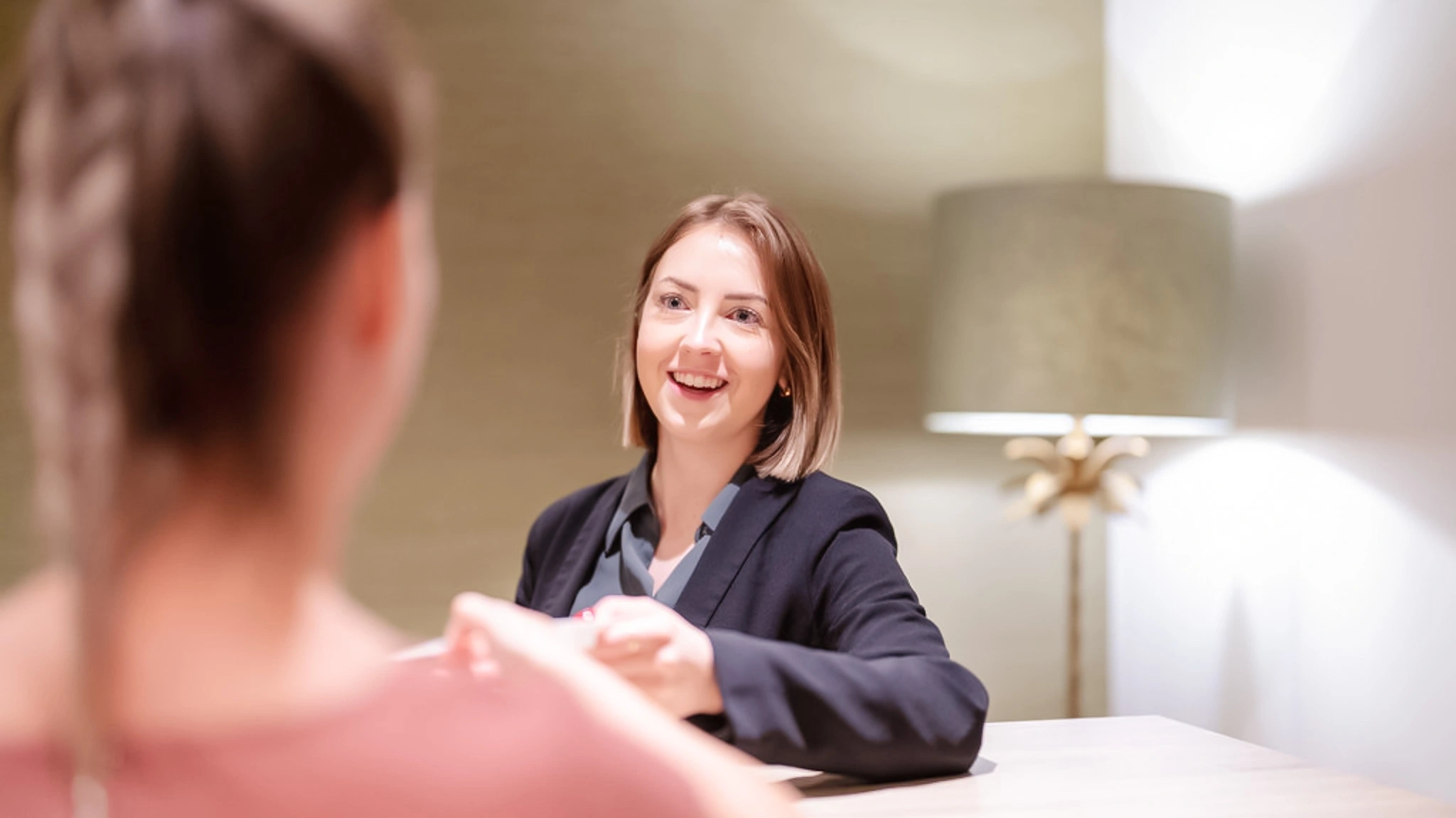 Eine Patientenmanagerin in der Vincera Privatklinik Spreewald überreicht einer neuen Patientin Unterlagen.
