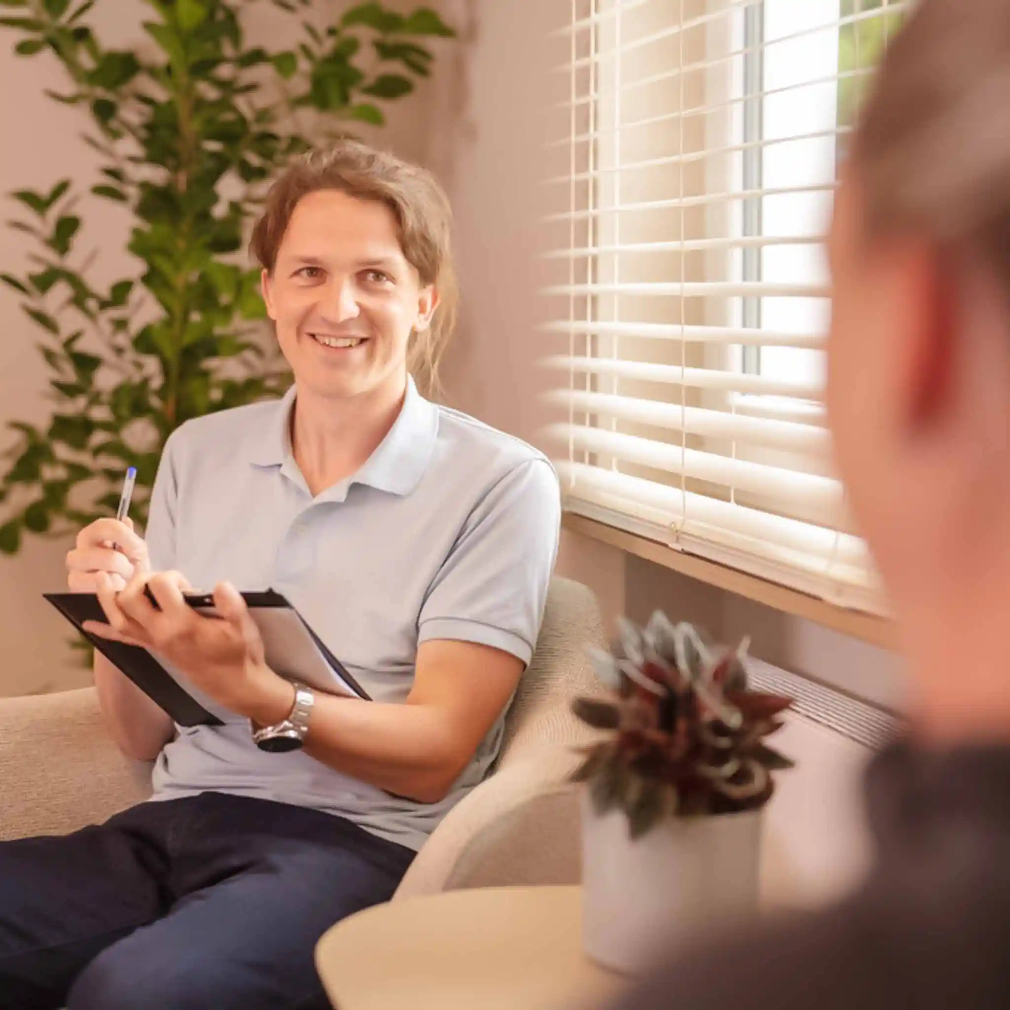Ein Therapeut bei der Psychotherapie mit einem Klemmbrett in der Hand