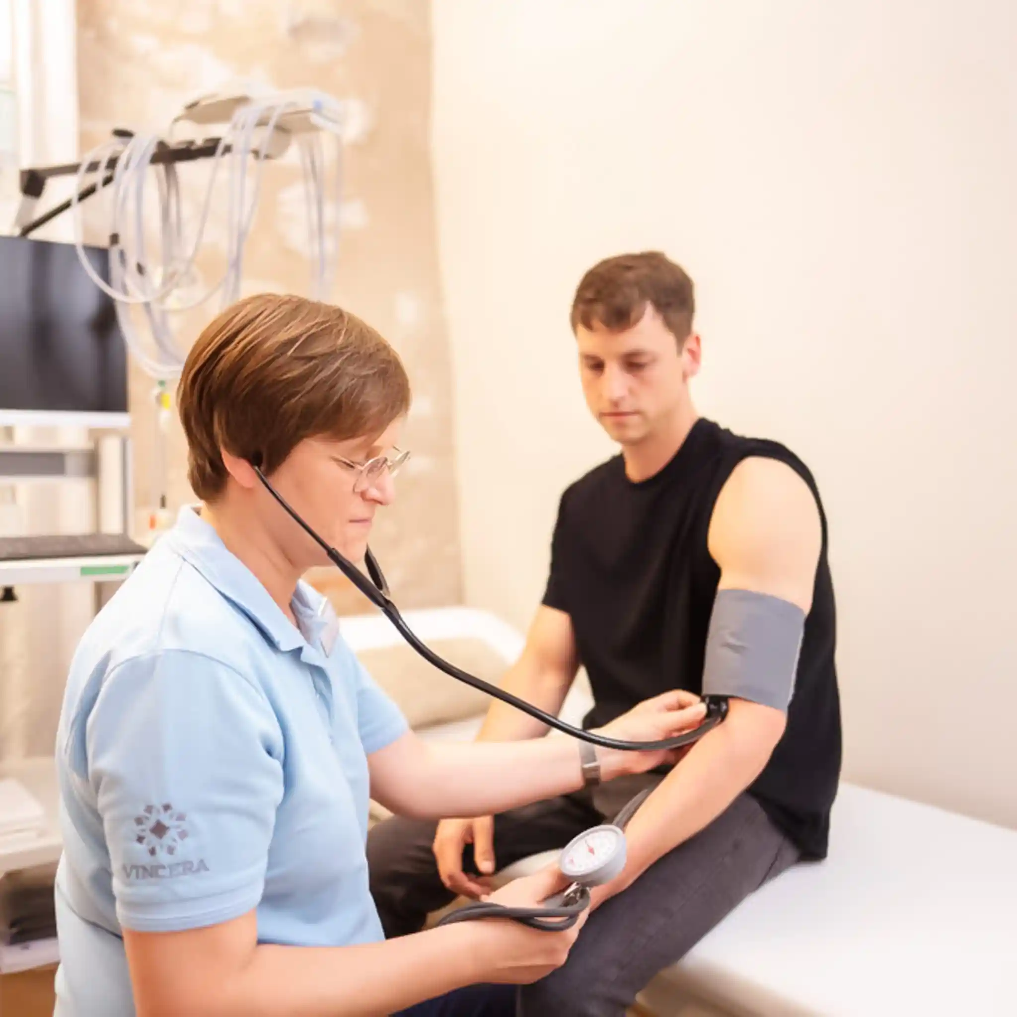 Eine Ärztin misst den Blutdruck eines Patienten. 