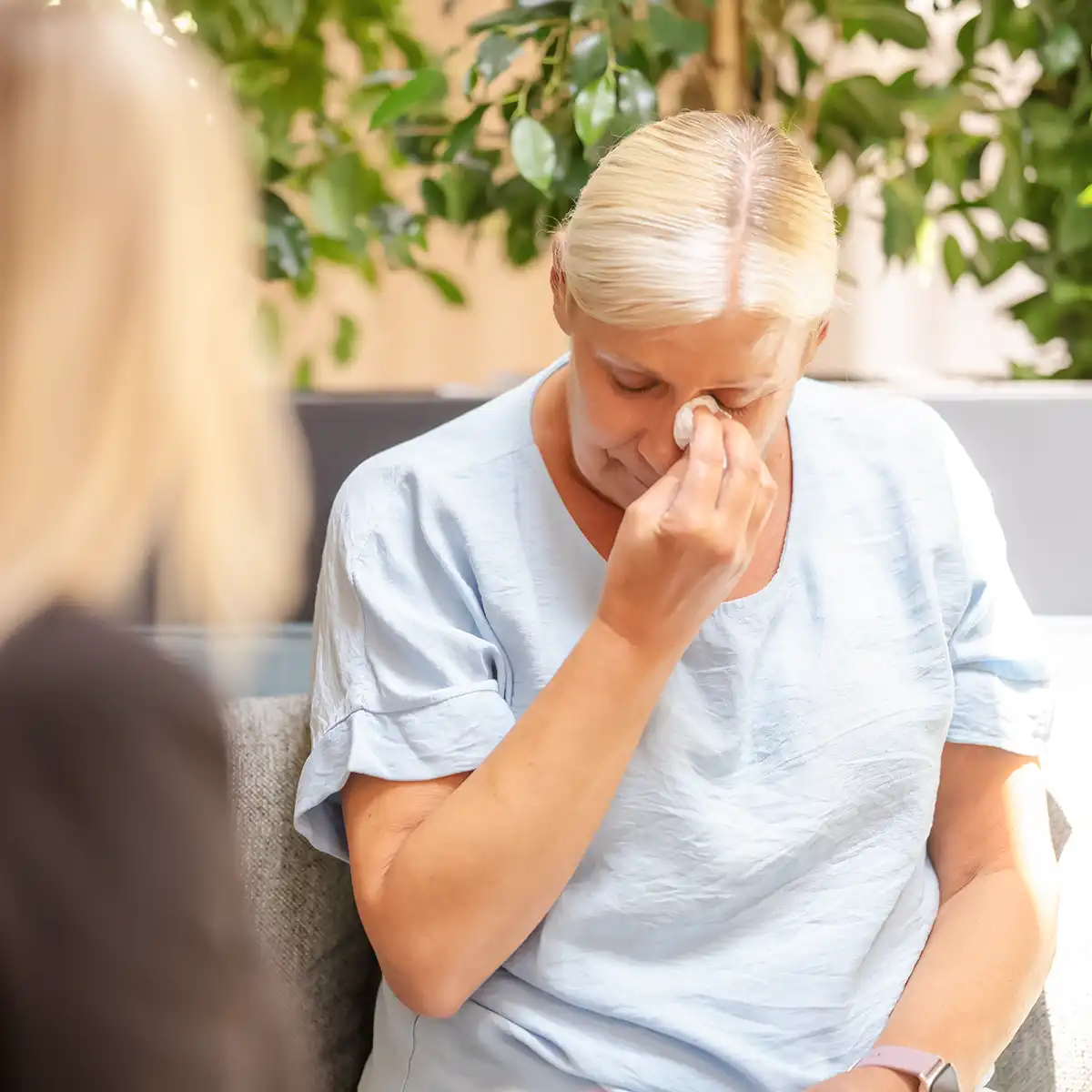 Eine weinende Patientin tupft sich die Tränen mit einem Taschentuch weg.