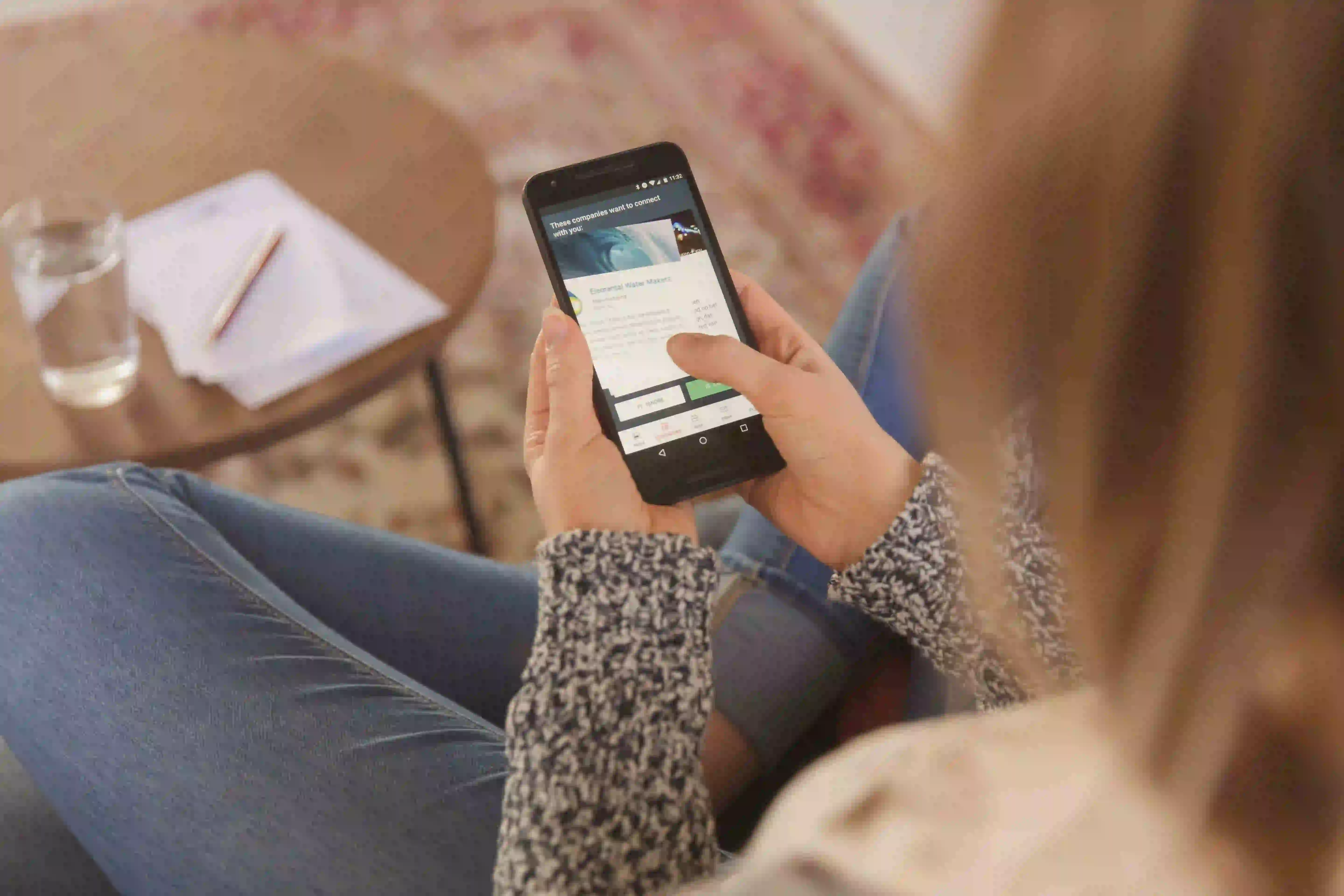 Eine Frau surft auf ihrem Smartphone.
