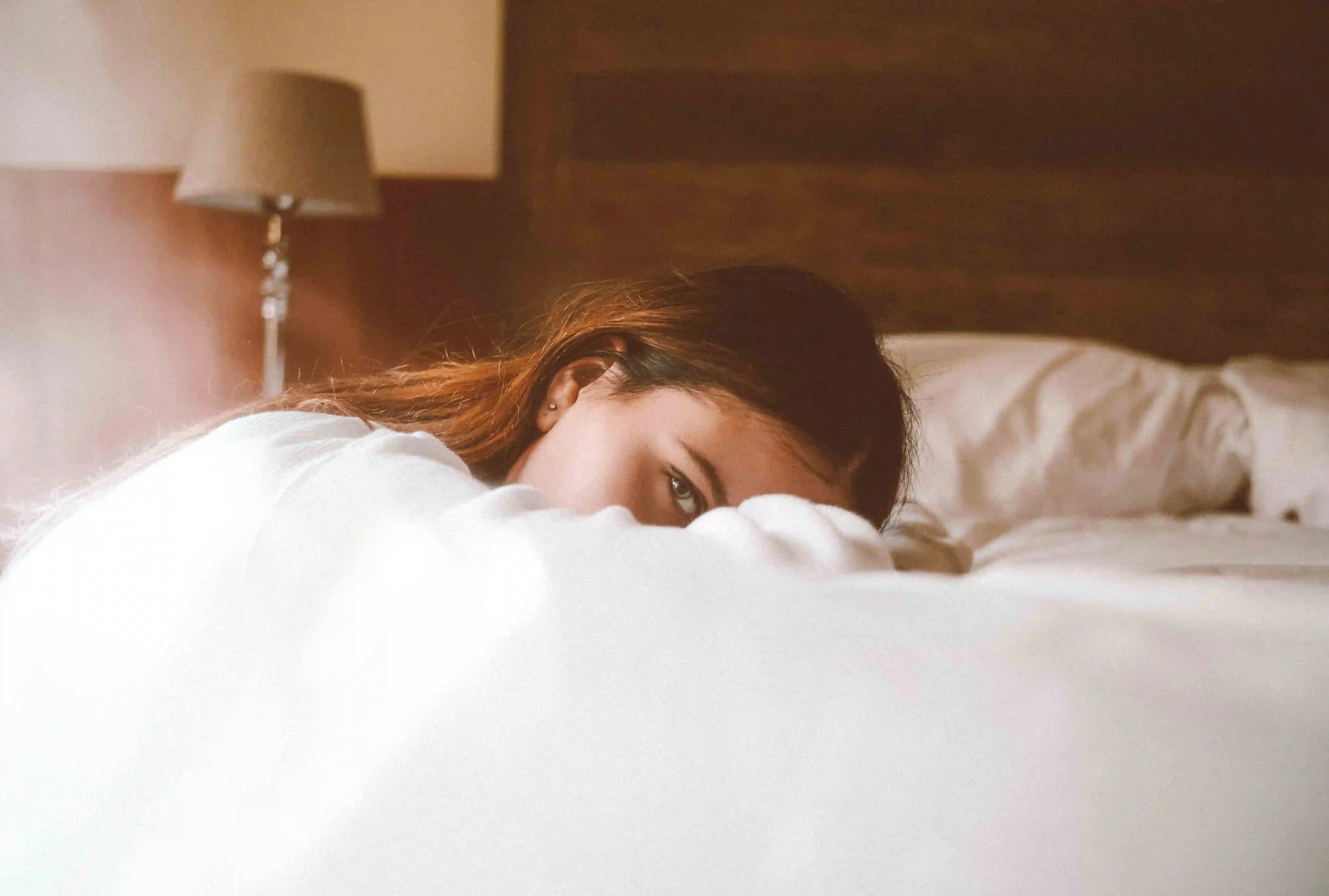 Eine unter Schlafstörungen leidende Frau liegt in ihrem Bett.