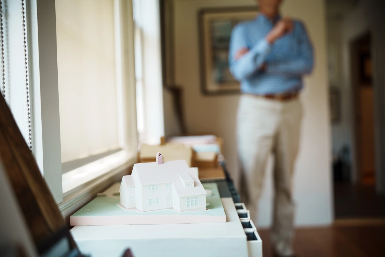 Architectural model of a home on display in the Benjamin Nutter Architects office, with architect in soft focus