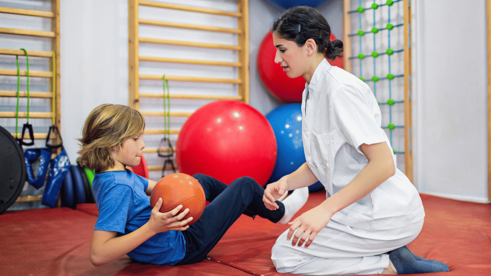 A woman and child sit together on the floor, representing pediatric physical therapy options in Austin, Texas