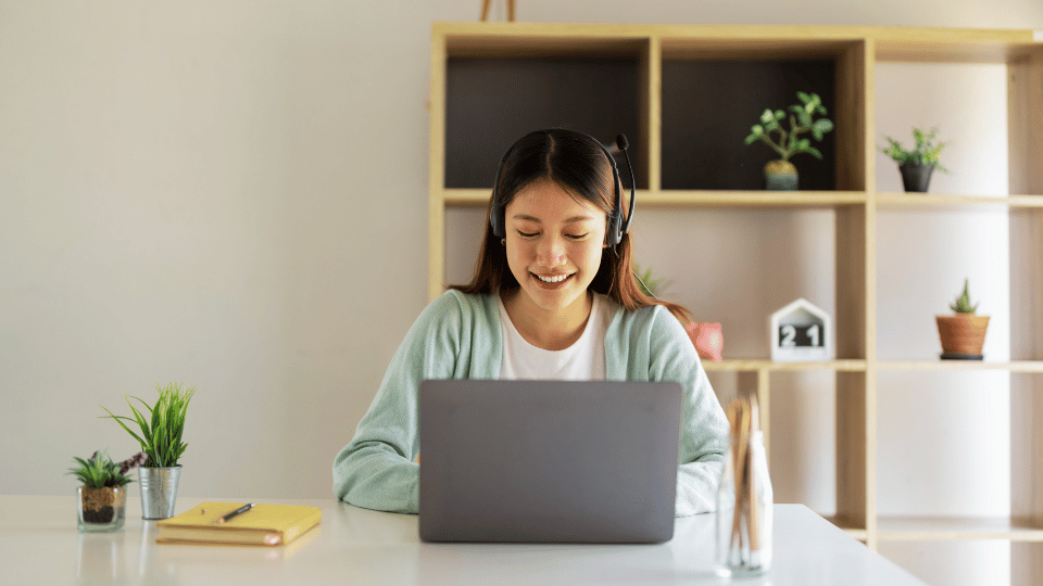A woman at a desk uses a laptop, engaging with content about free CEU physical therapy courses.