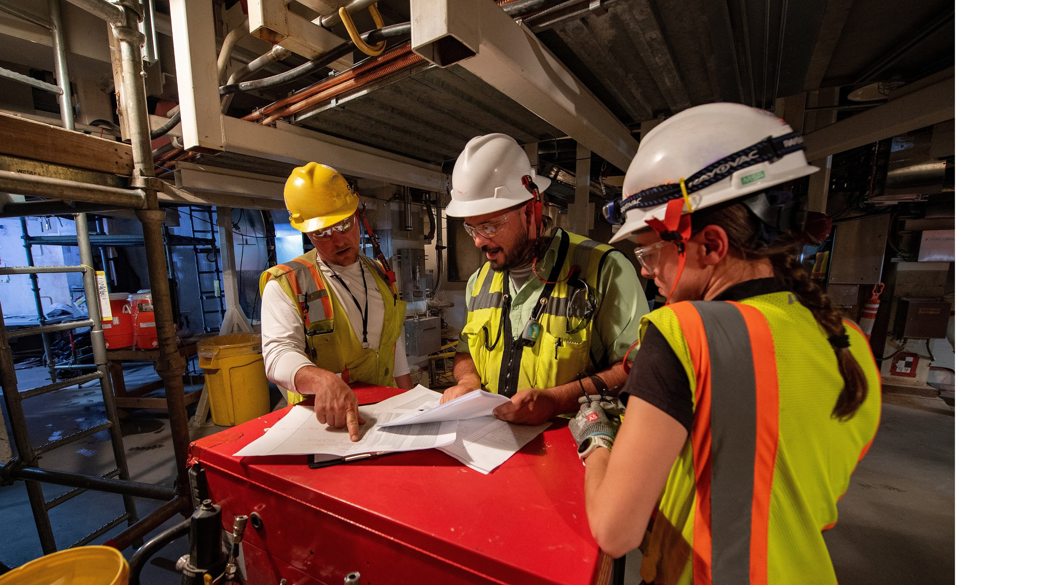 Three workers with hard hats.