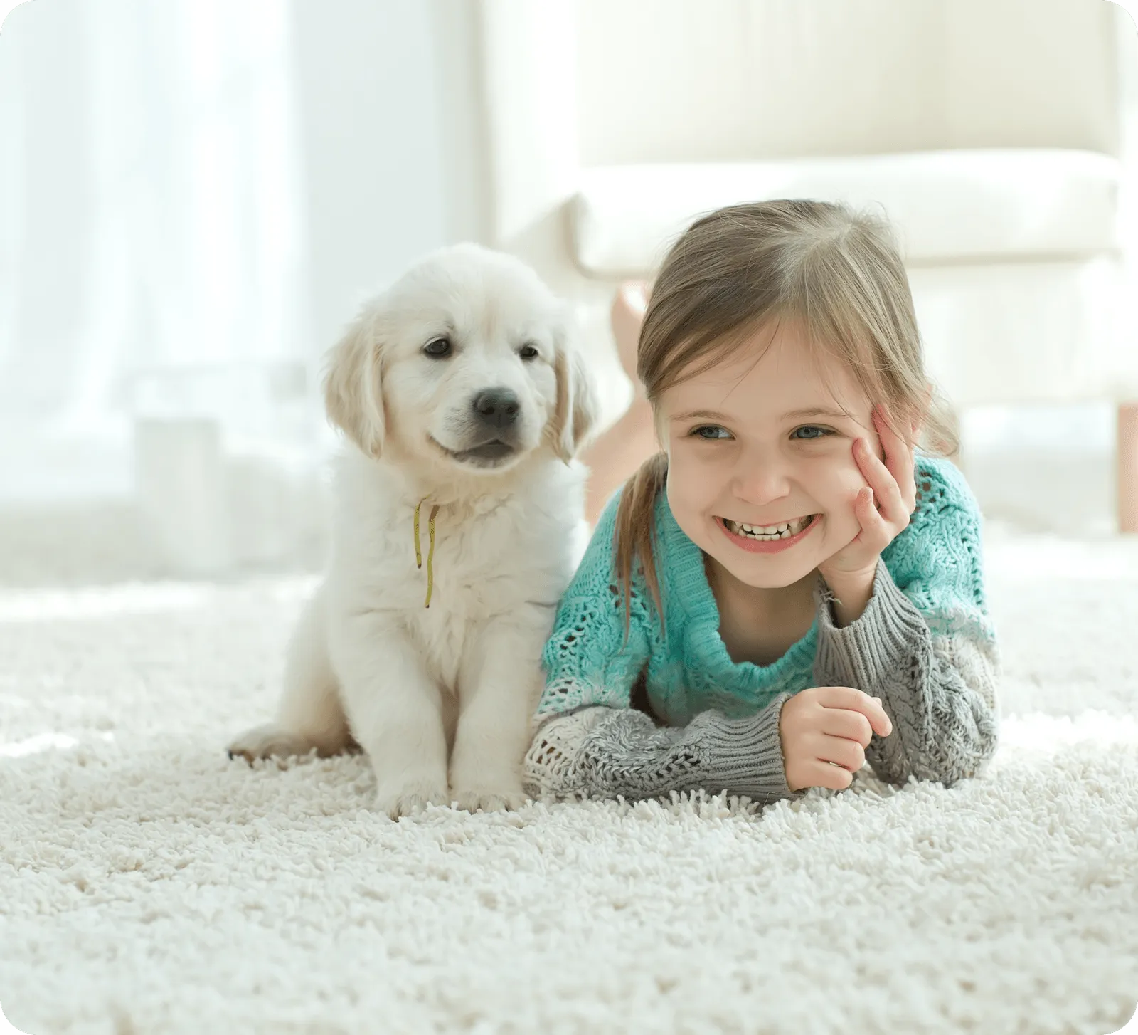Young girl lying down on a carpet next to a dog