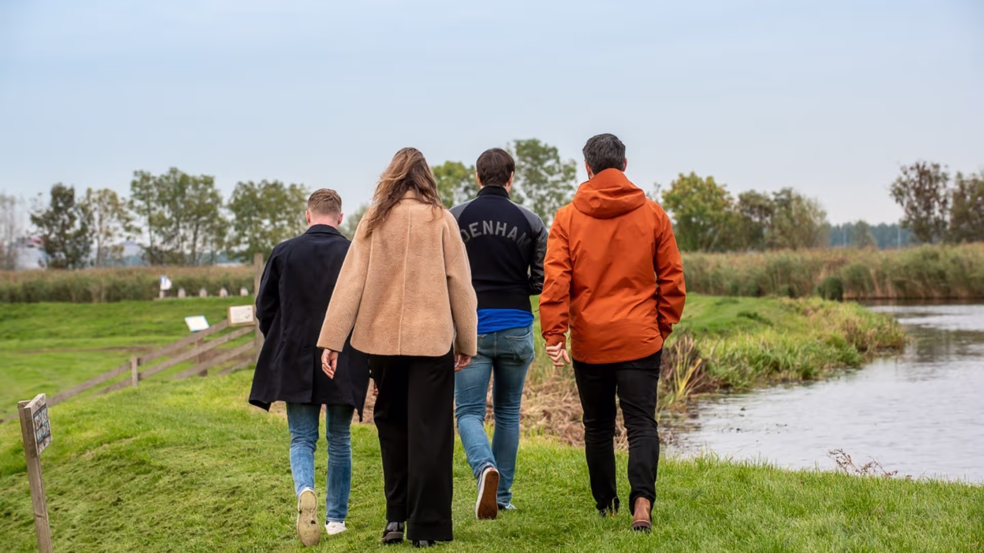 Groepje is aan het wandelen over het dijkje.