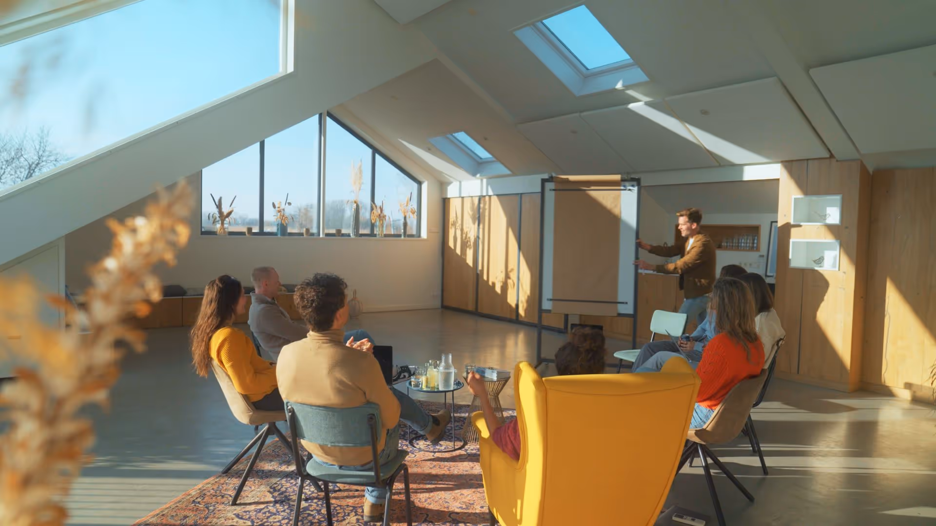 Groep die luistert naar een presentatie bij een flip-over, breder aanzicht