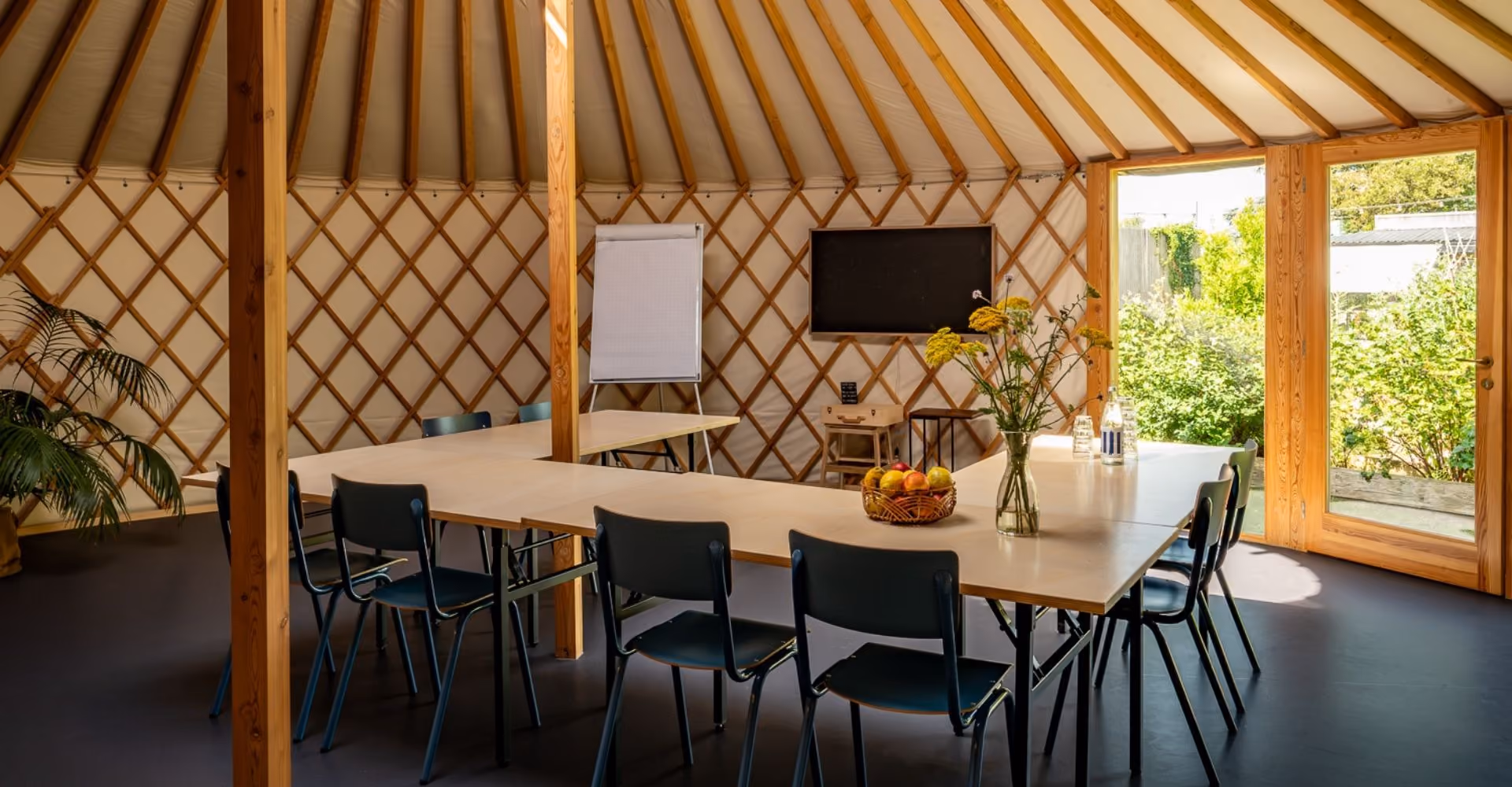 Lange vergadertafel met stoelen in de Yurt