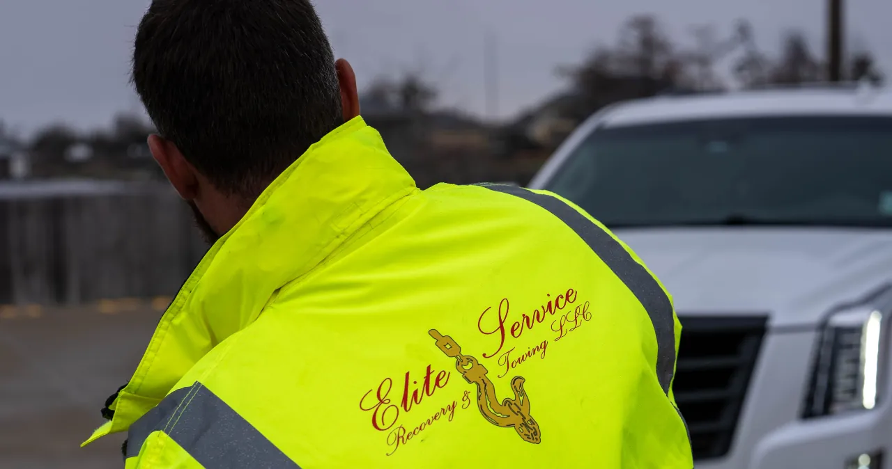Elite Towing Technician Beside Service Vehicle