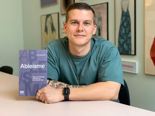 Author Emil Falster with his book Ableisme