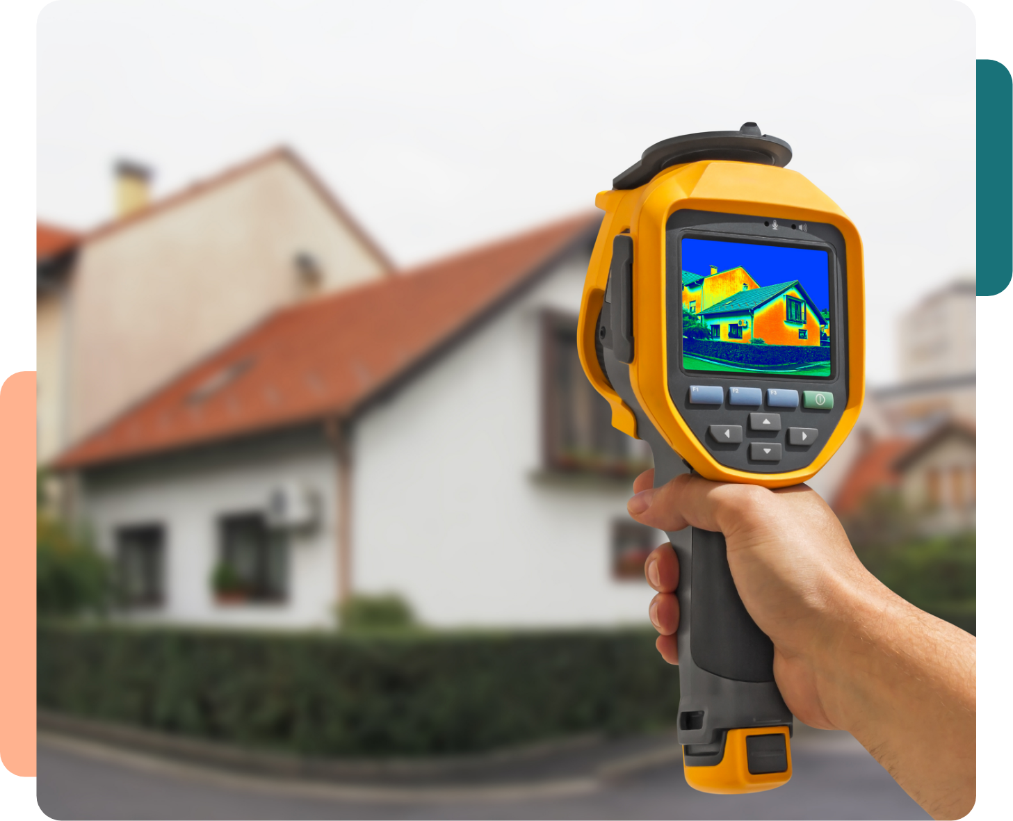 Main tenant une caméra thermique avec l'image d'une maison analysée