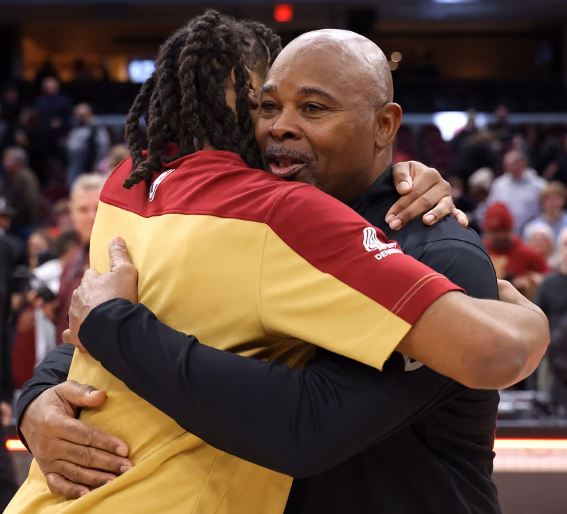 Assistant Coach Sidney Lowe of the Detroit Pistons and Darius Garland #10 of the Cleveland Cavaliers embracing in a hug inside a basketball arena