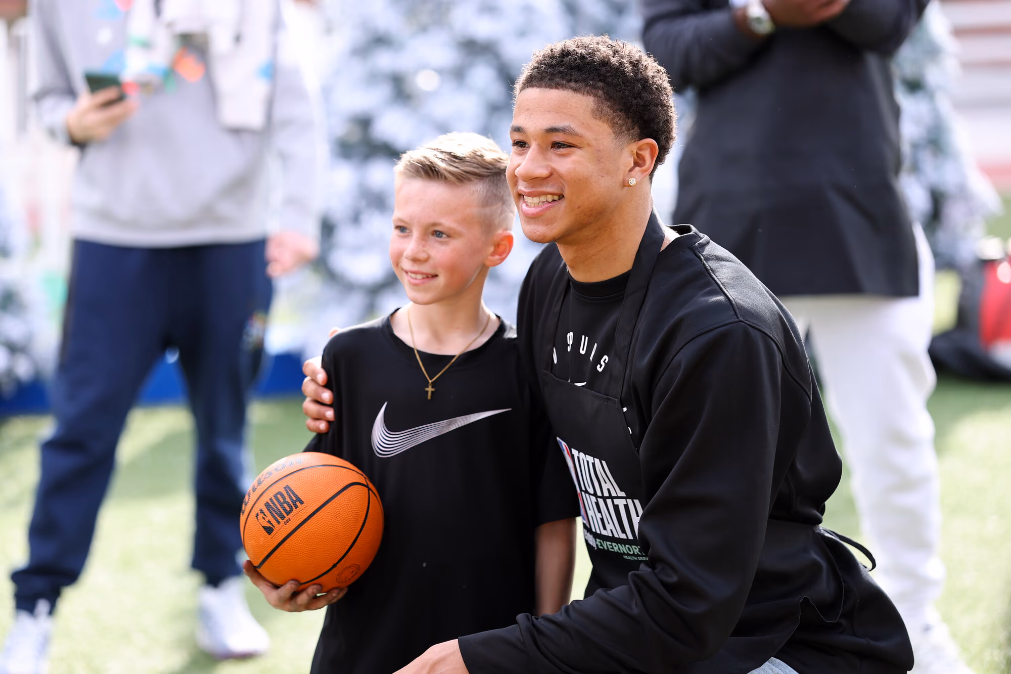 carter bryant of san antonio spurs att a community event posing with kid