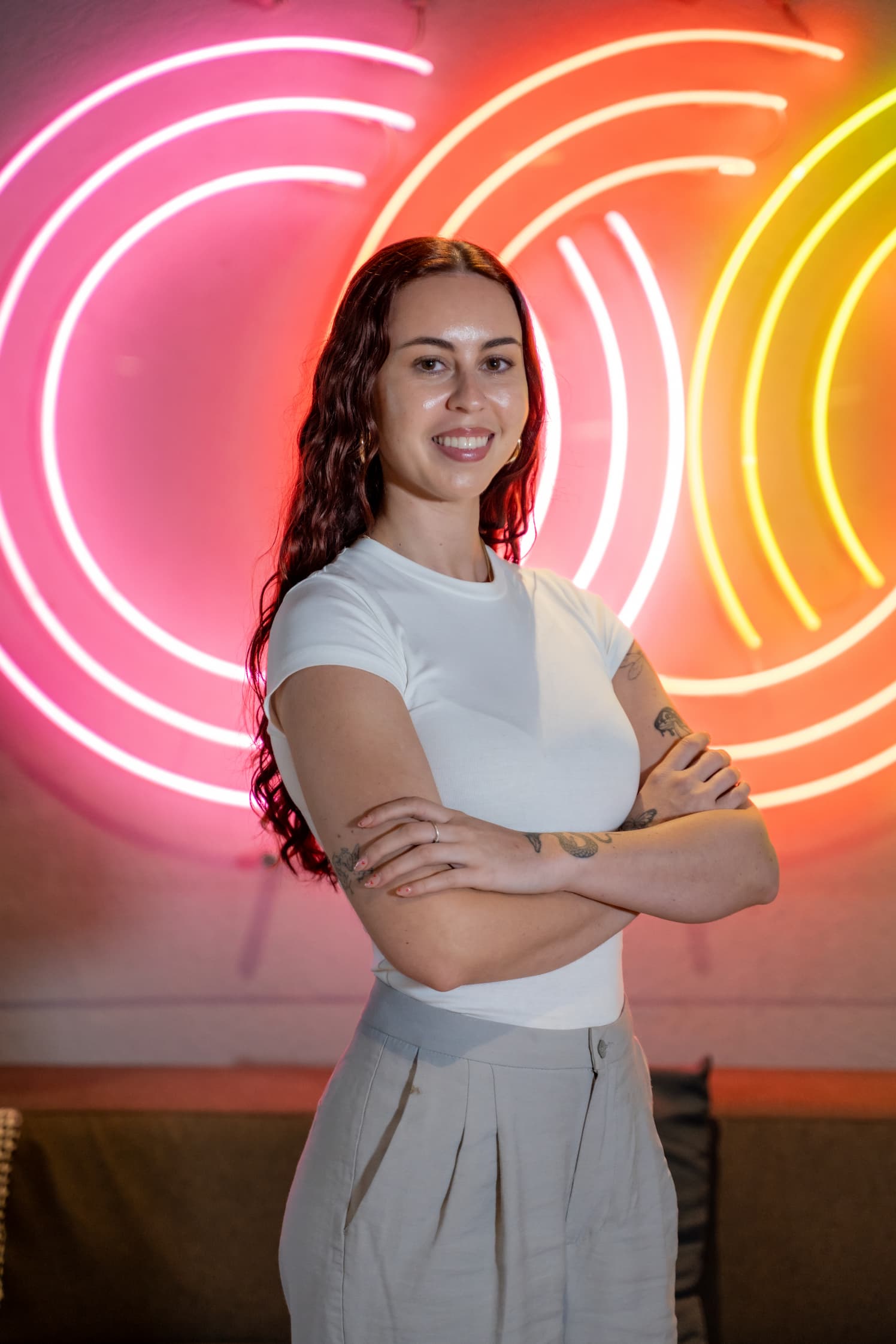 Tammy from MyOutreach standing in front of the neon wall