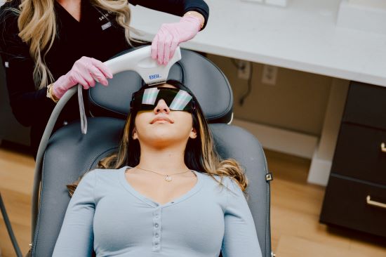 A woman with googles receives a photofacial treatment