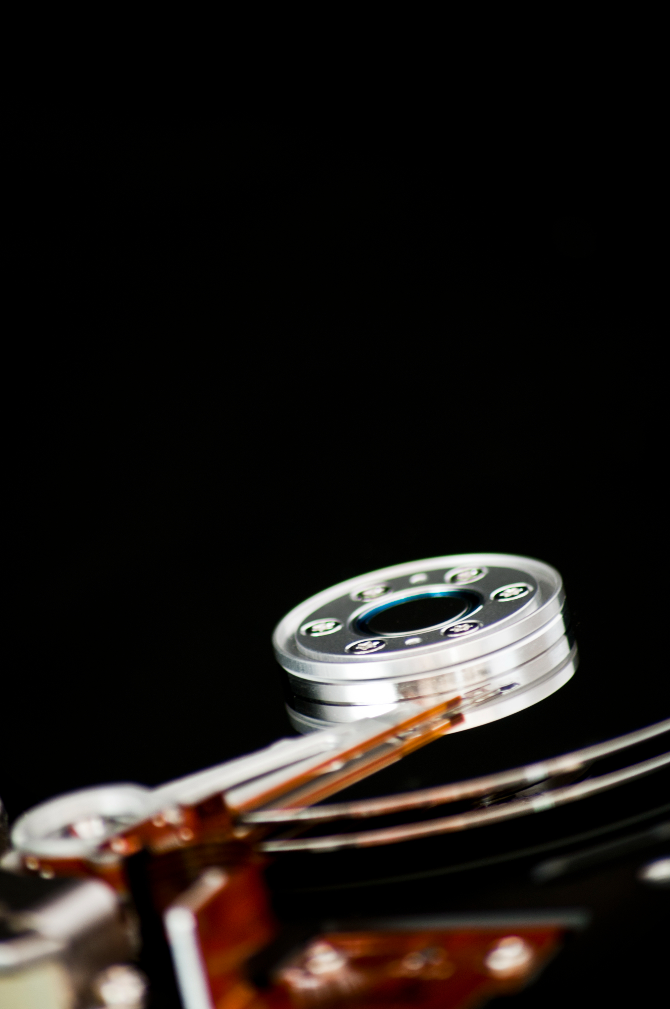 Nahaufnahme der inneren Komponenten einer Festplatte mit sichtbarer Oberfläche und Aktuatorarm.