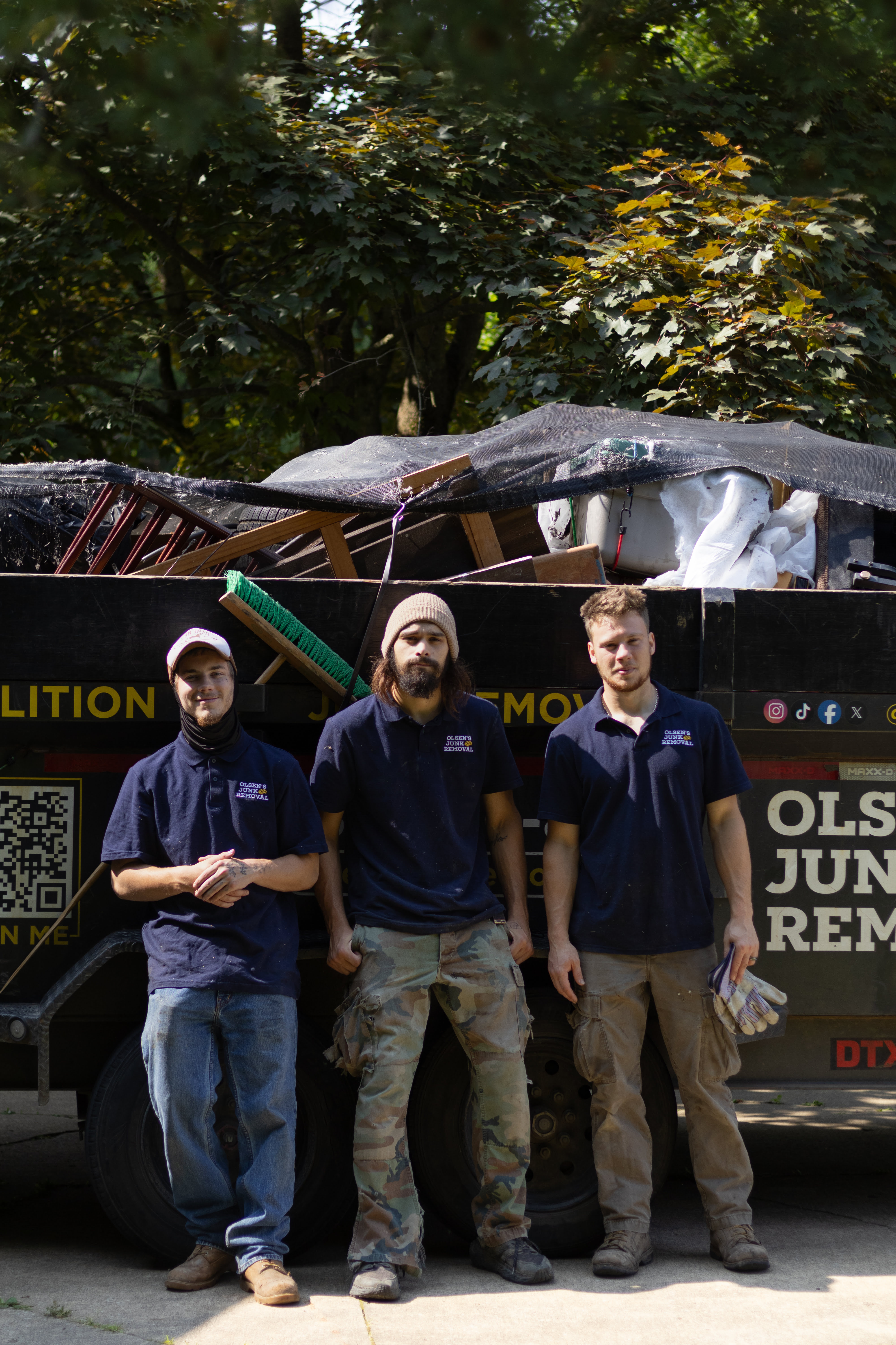 Man unhooking dump trailer with his back facing the camera in Massillon Ohio