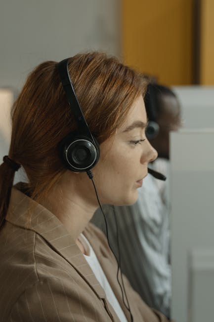A dedicated call center agent wearing headphones assisting clients. Professional customer support environment.