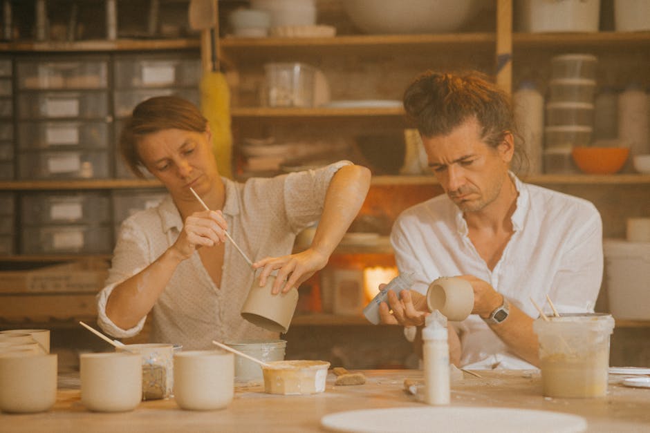 Two adults crafting ceramics in a creative studio workspace.