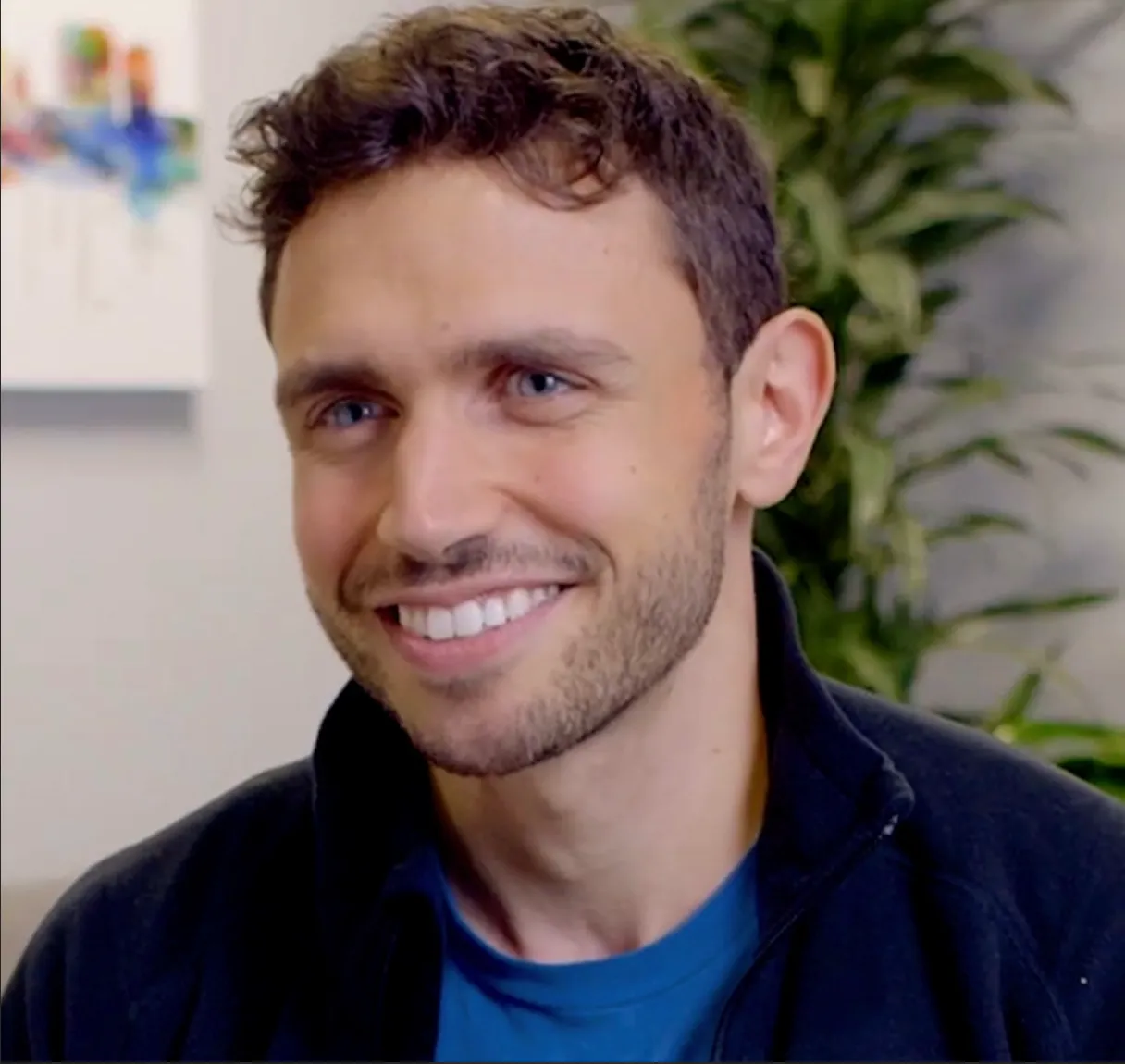 Portrait of a smiling man in a navy zip jacket