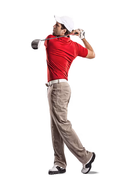 Male golfer in red shirt and beige pants finishing a golf swing against a black background.