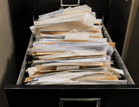 A filing cabinet drawer overflowing with years of unsorted paperwork