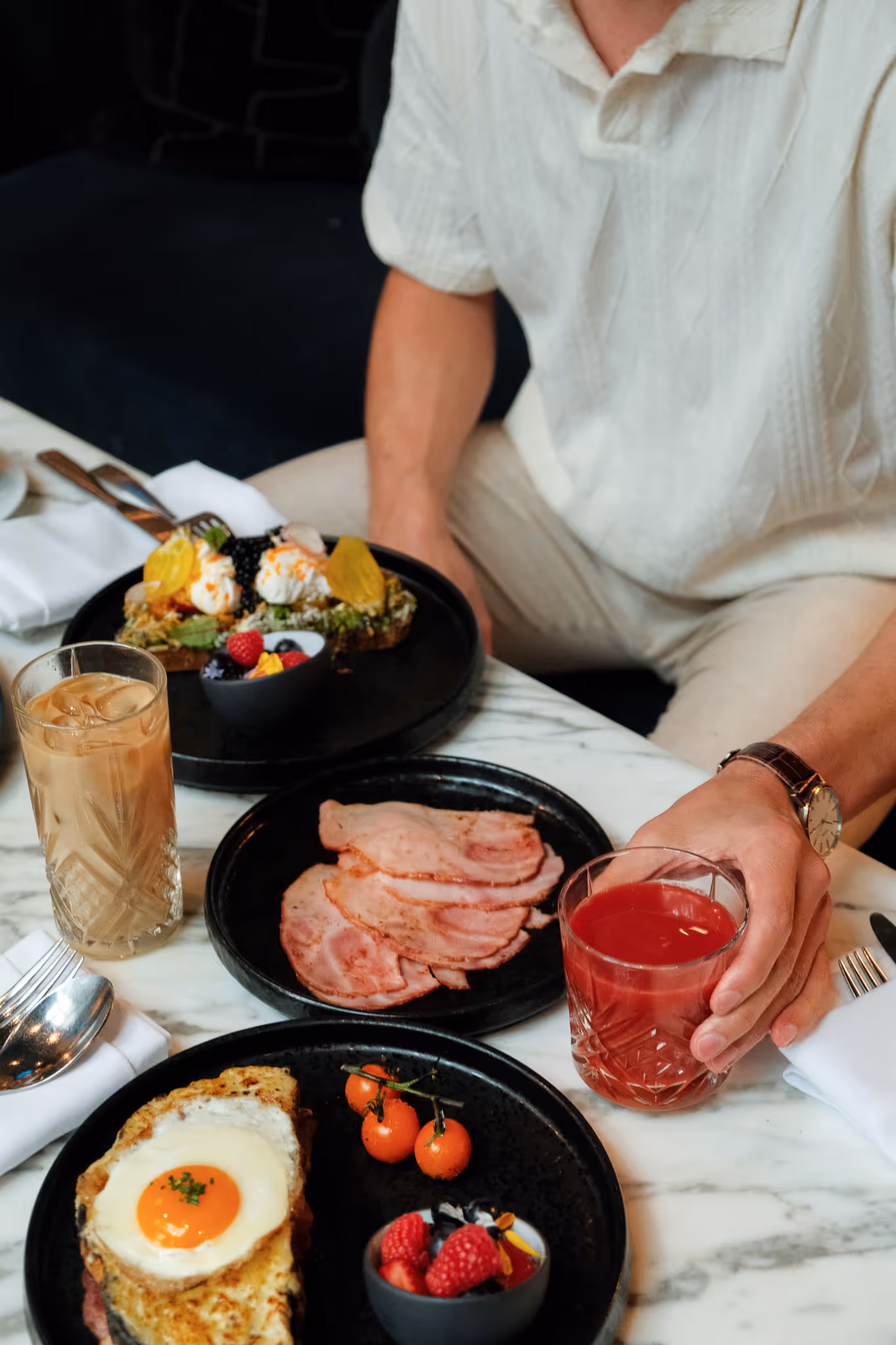 A guy has avocado toast & breakfast sandwich at Paradox Hotel Vancouver
