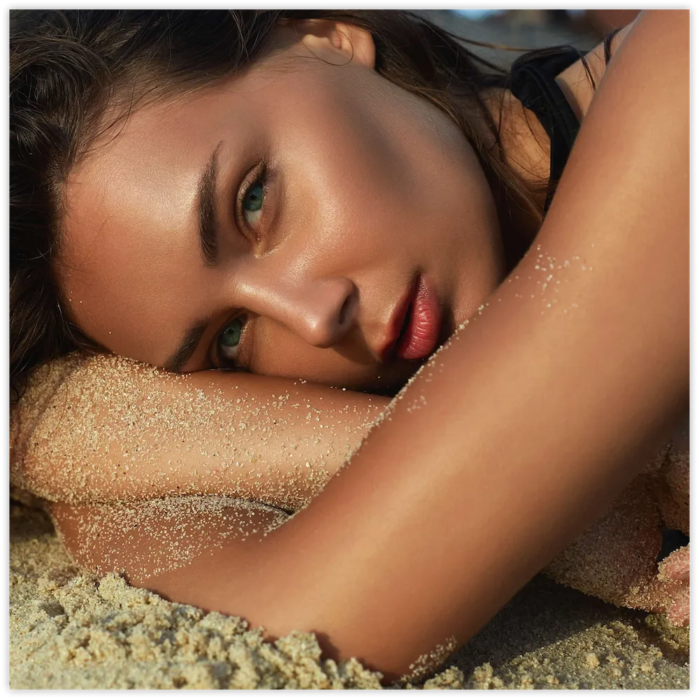 Woman with natural facial volume resting on the sand, fat transfer injections in Chattanooga, TN