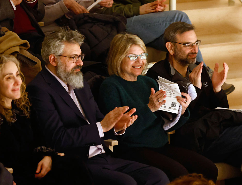 A group of people in the audience smiles and applauds. Photo by Winslow Townson.