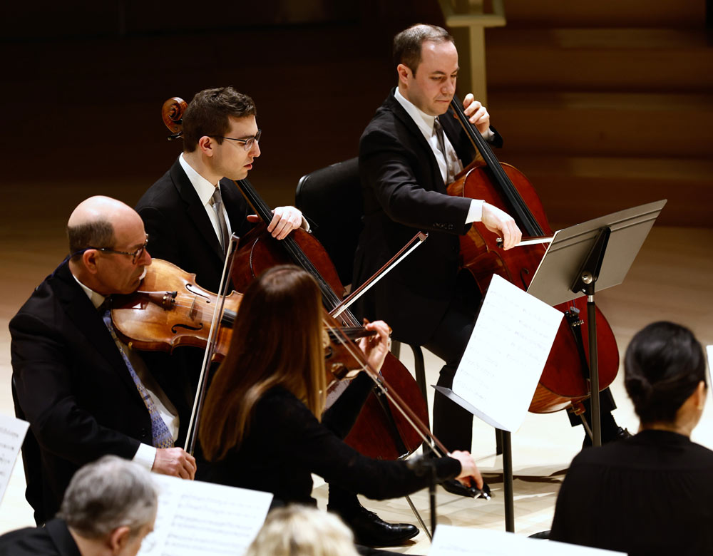 A group of string musicians performs on stage. Photo by Winslow Townson.