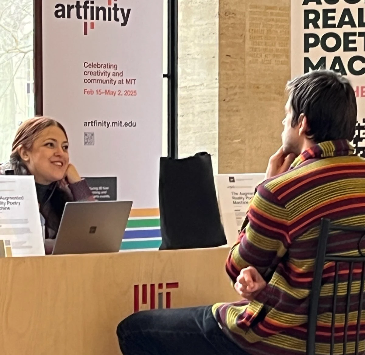 Poet Monica Storss greets a participant of the Augmented Reality Poetry Machine in MIT Memorial Lobby. Courtesy of the artist.