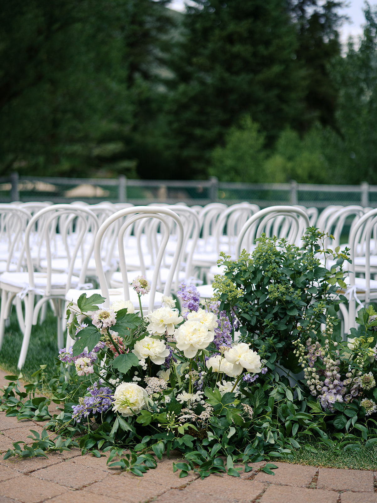 Meadow-style ceremony aisle florals with white and lavender blooms lining chairs at a Sun Valley outdoor wedding