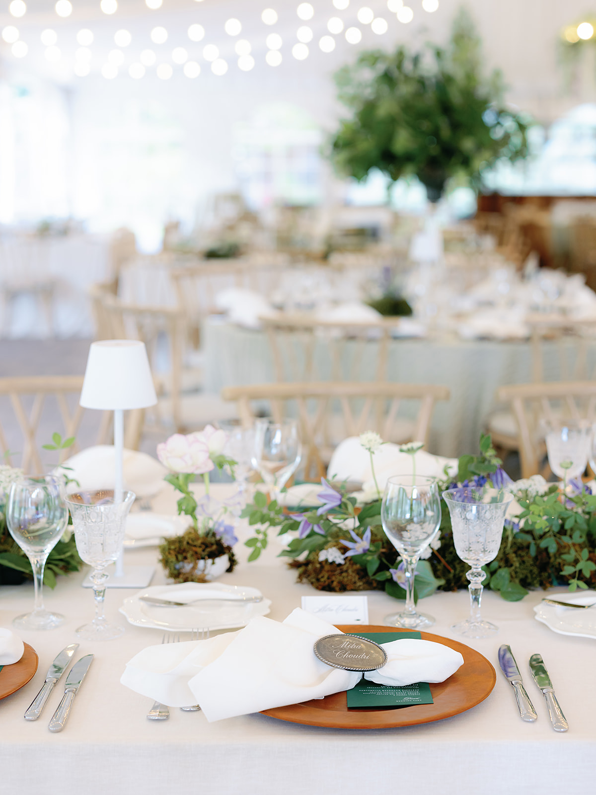 Garden-inspired reception table with mossy floral runner, white linens, wood chargers, and lavender accents at a Sun Valley wedding