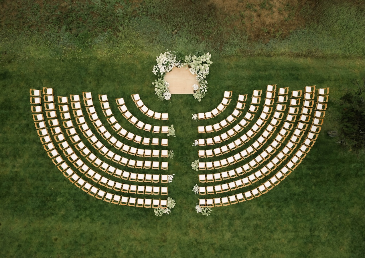 Overhead image of McCall wedding ceremony curved seating around ceremony stage with lush flowers