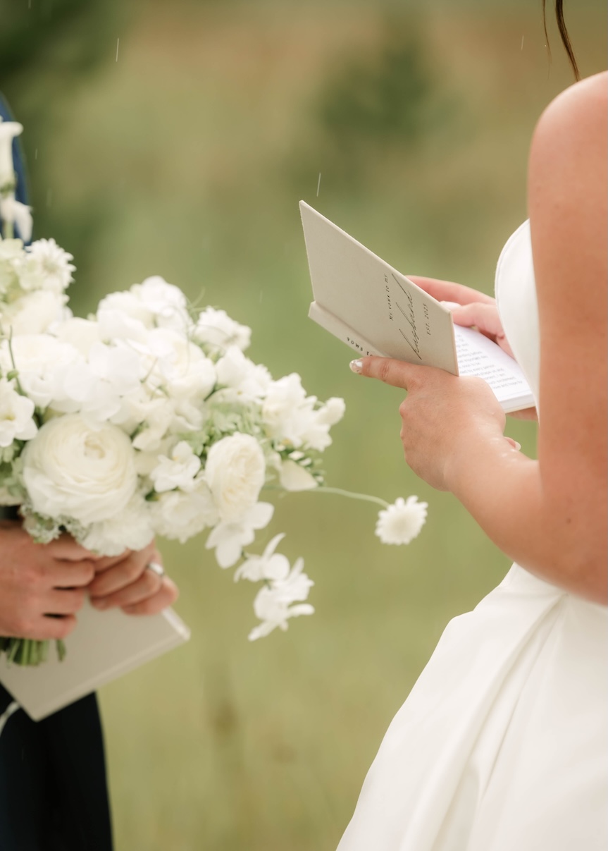 Up-close of groom holding a white bridal bouquet in front of bride McCall idaho 
