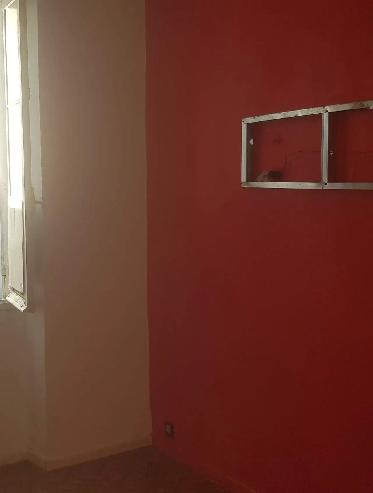 Le mur rouge et les rails du vendeur de la chambre 1 avant la rénovation