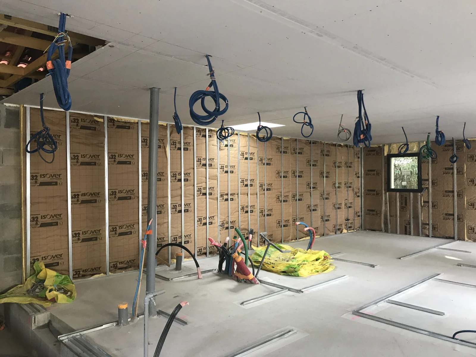 Pose de cloisons et de réseaux dans une pièce en cours de rénovation.
