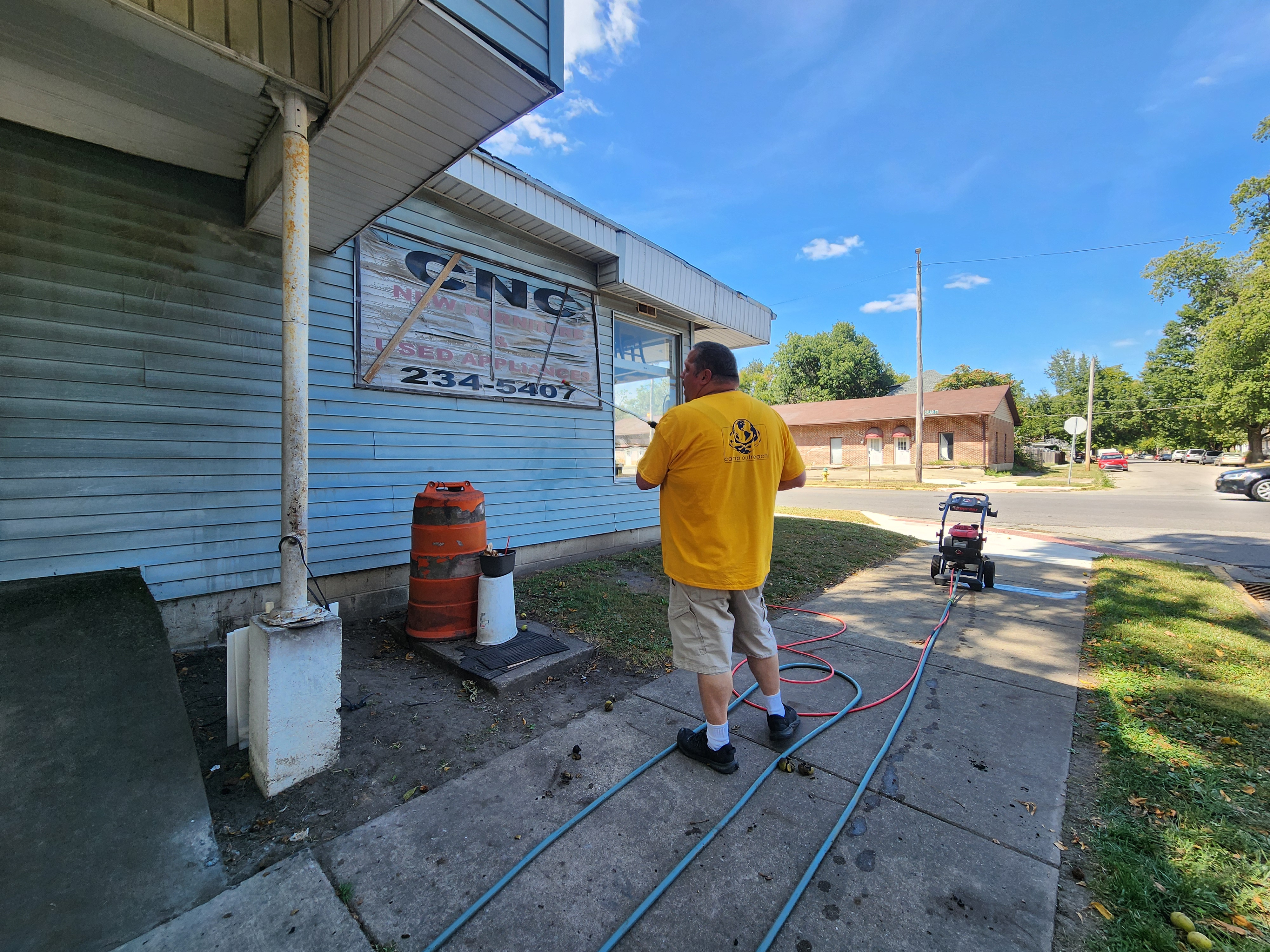 Member pressure washing local business during our community service project, May 2026.